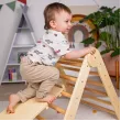 Triunghiul Pikler ajută la explorarea și dezvoltarea în siguranță a limitelor de mișcare ale copilului.