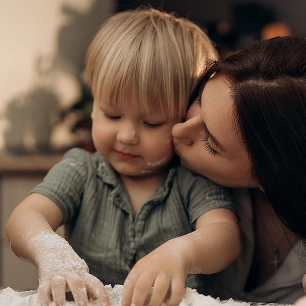 Mama își sărută copilul în timpul unei activități liniștite